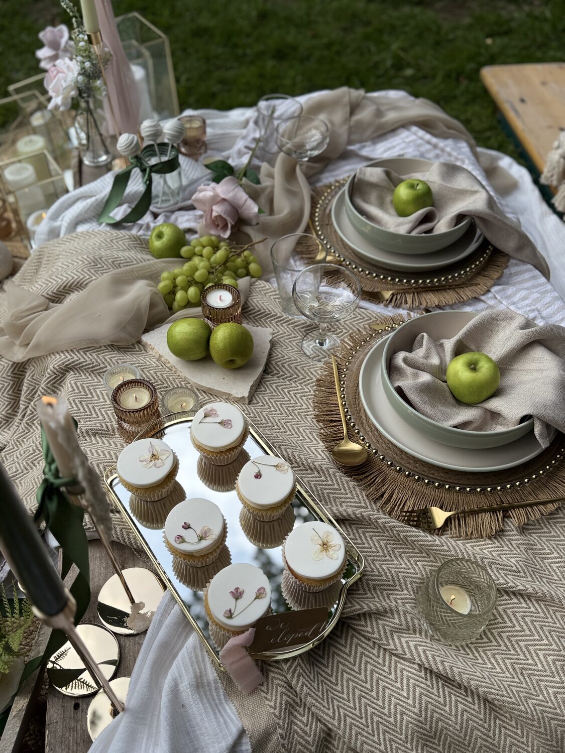 Styled wedding picnic table with plates, green apples and cupcakes