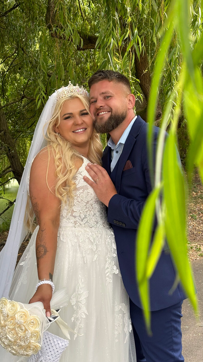 Bride and groom together under the willow tree