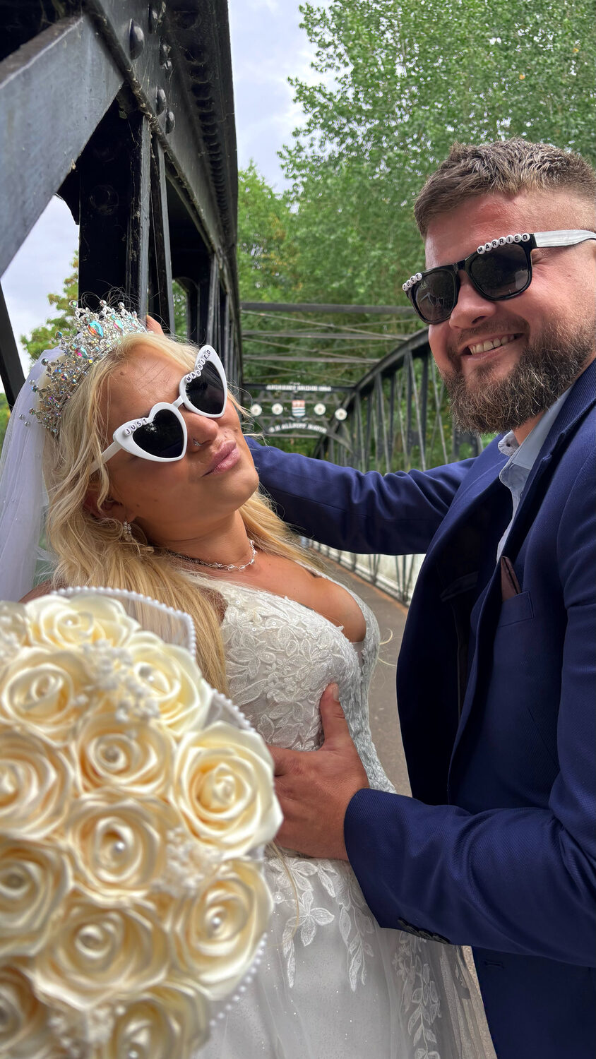 Bride and groom wearing Just Married sunglasses